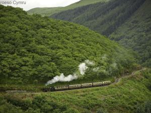 LlanilarにあるHoliday Home Bwthyn Cadair by Interhomeの煙が来る山を下る列車