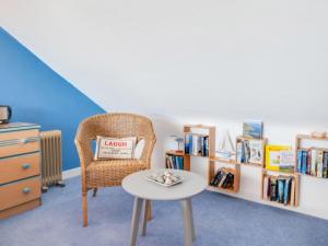 a room with a chair and a table and bookshelves at Apartment Harbour View by Interhome in Aberaeron