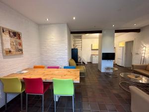 een kamer met een houten tafel en kleurrijke stoelen bij Holiday Home Bungalowpark Landsrade by Interhome in Gulpen