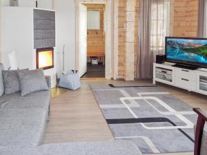 ein Wohnzimmer mit Couch und Flachbildfernseher in der Unterkunft Holiday Home Nesterin helmi by Interhome in Eno