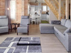 ein Wohnzimmer mit einem Sofa und Stühlen sowie eine Küche in der Unterkunft Holiday Home Nesterin helmi by Interhome in Eno