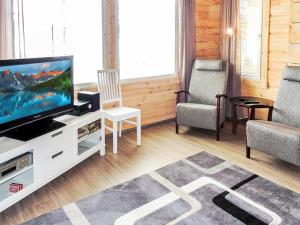 ein Wohnzimmer mit einem TV und 2 Stühlen in der Unterkunft Holiday Home Nesterin helmi by Interhome in Eno + 20 Fotos