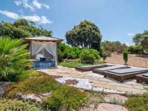 Villa Essenthia by Interhome في ألغيرو: حديقة خلفية مع شرفة وفناء