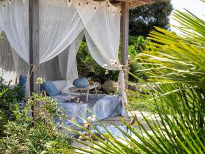 Cama con dosel en medio de un jardín en Villa Essenthia by Interhome, en Alghero