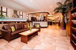 a lobby with a couch and a coffee table at Stadthotel Stern in Wismar