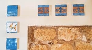a wall with blue and orange tiles on a wall at Gurgiolo New Apartment in Trabia