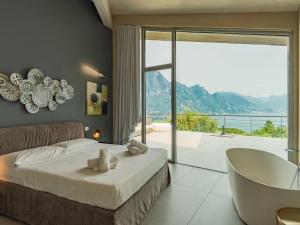 1 dormitorio con cama, bañera y balcón en Villa Villa Gau' by Interhome, en Riva di Solto