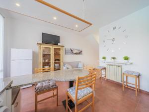 a kitchen with a table and chairs and a clock on the wall at Apartment Villaggio 5 Terre-6 by Interhome in Soviore