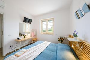 a bedroom with a bed and a desk and a window at HelloApulia Villa Capitolo Beach in Monopoli