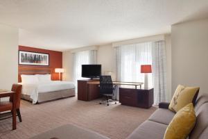 Residence Inn Joplin في جوبلين: غرفة في الفندق مع سرير ومكتب