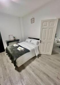 um quarto com uma cama e uma porta branca em Flat 3 Battersea Park Rd, 2 bedroom, 1 Bathroom flat em Londres