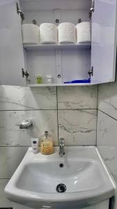 Baño con lavabo blanco y rollos de papel higiénico en Flat 3 Battersea Park Rd, 2 bedroom, 1 Bathroom flat, en Londres