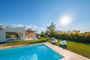 a backyard with a swimming pool and a house at HelloApulia Villa Capitolo Beach in Monopoli