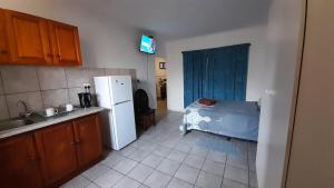 a kitchen with a refrigerator and a bed in it at Umkomaas Lodge in Umkomaas