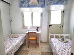 een slaapkamer met 2 bedden, een bureau en een tafel bij Mattis Seafront Beachhouse in Perivolia