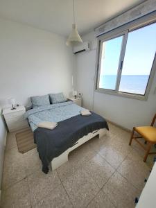 a bedroom with a large bed and a large window at Mattis Seafront Beachhouse in Pervolia