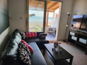 een woonkamer met een bank, een tv en een tafel bij Mattis Seafront Beachhouse in Perivolia