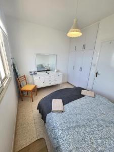 a bedroom with a large bed and a dresser at Mattis Seafront Beachhouse in Perivolia