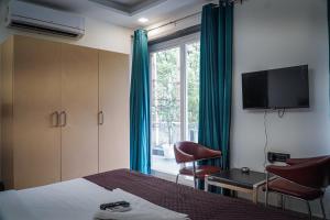 ein Hotelzimmer mit einem Bett, einem TV und einem Fenster in der Unterkunft Hotel Leaf studio Medicity in Gurgaon