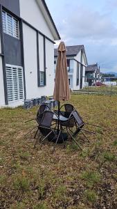 甘孟的住宿－Nafisa 3 Homestay，院子里的桌椅和雨伞