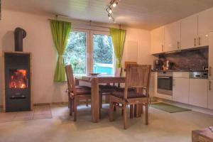 a kitchen with a table and chairs and a fireplace at Spree am See - Dein Ferienhaus in Markische Heide