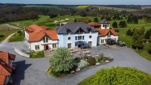 an aerial view of a large white house with orange roofs at Darovanský Dvůr - Wellness & Golf Hotel in Břasy