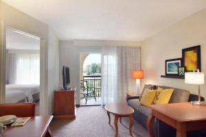 a living room with a couch and a room with a balcony at Residence Inn Joplin in Joplin