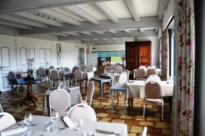 a dining room with white tables and chairs at Hotel Lou Granva in Grande Riviere