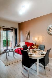 a living room with a table and a bed at Appartement moderne central avec piscine, garage privé et terrasse sud in Uzès