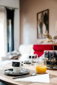 een tafel met een kopje koffie en een glas sinaasappelsap bij Appartement moderne central avec piscine, garage privé et terrasse sud in Uzès