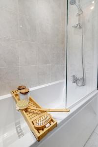W łazience znajduje się wanna z tacą i prysznicem. w obiekcie Modern 1 bed-Nr Warner Bros-Parking-Garden w mieście Watford