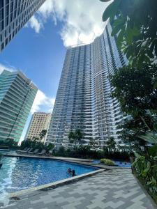 a large building with a swimming pool in front of it at E & T Homecation 2 Bedroom at SMDC Air Residences in Manila