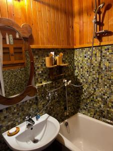 ein Badezimmer mit einem Waschbecken, einem WC und einer Badewanne in der Unterkunft Cosy house with forest view in Pyussi