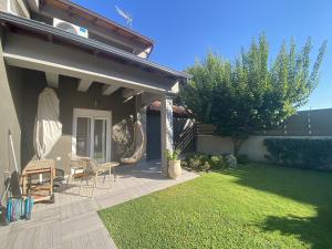 a patio with two chairs and a table on a lawn at Villa ELi - Luxury Nature Getaway - Strategically located for Beach Exploration - Onsite Power for Electric Vehicle in Fourka
