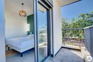 a bedroom with a bed and a balcony at T3 - Le Tropical - proche centre Saint-Louis in Saint-Louis