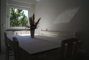 a dining room table with a vase of flowers on it at 3 L's STAY in Castro Daire