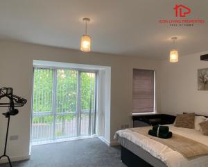 een slaapkamer met een bed en een groot raam bij Modern Spacious 4 Bed House By Icon Living Properties Short Lets & Serviced Accommodation Reading With Free Parking in Reading