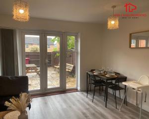 a living room with a table and a patio door at Modern Spacious 4 Bed House By Icon Living Properties Short Lets & Serviced Accommodation Reading With Free Parking in Reading