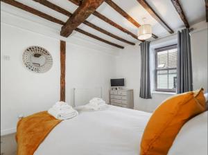 um quarto com uma grande cama branca com vigas de madeira em Characterful 3 Bedroom Cottage em Aberystwyth