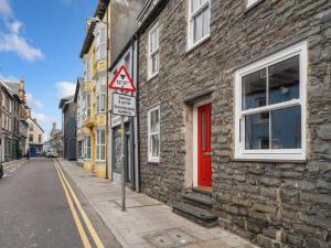 a brick building with a red door on a street at Characterful 3 Bedroom Cottage in Aberystwyth