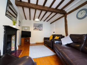 a living room with a couch and a clock on the wall at Characterful 3 Bedroom Cottage in Aberystwyth