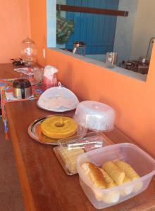 Pousada Pérola do Rio في باريرينهاس: كونتر خشبي مع طاولة عليها طعام