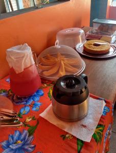 a table with a drink and a slow cooker on it at Pousada Pérola do Rio in Barreirinhas