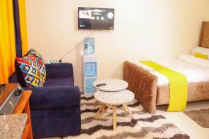 a living room with a bed and a chair and a table at BASICS HOME STAYS in Nairobi