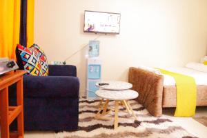 a living room with a bed and a table and a couch at BASICS HOME STAYS in Nairobi