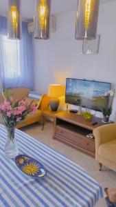 uma sala de estar com uma televisão e uma mesa em Apartment Dmitr Petrovac em Petrovac na Moru