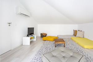 um quarto branco com uma cama e um sofá em Special Cabanas em Tavira