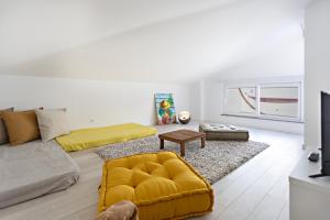 uma sala de estar com um sofá amarelo e uma mesa em Special Cabanas em Tavira