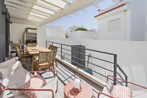 a balcony with a table and chairs and a kitchen at Special Cabanas in Tavira