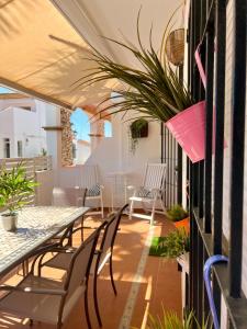 a patio with tables and chairs and plants at Casa El Faro in El Rompido